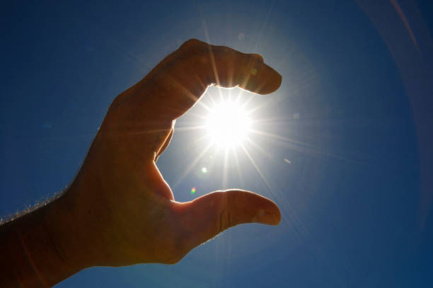 istock One Hand Catching the Sun Stars on a Blue Background 1387276050
