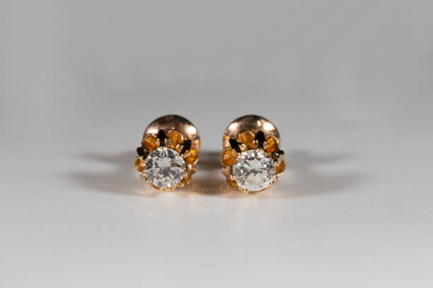 istock Yellow gold earrings with natural round diamonds on a white background 1387278531