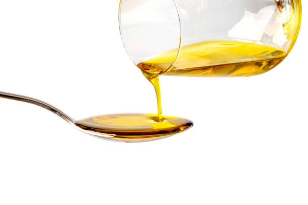 Extra virgin oil poured in spoon Extra virgin oil poured from glass into spoon, isolated on white background, clipping path olive oil pouring antioxidant liquid stock pictures, royalty-free photos & images