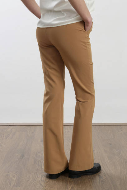 istock Female model wearing beige tailored trousers. Studio shot. 1387279630