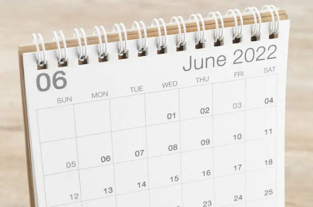 The June 2022 desk calendar on wooden background.