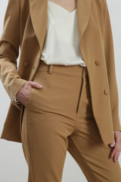 istock Female model wearing beige tailored suit and white silk top. Studio shot. 1387280813