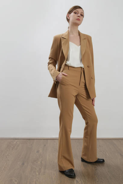 istock Female model wearing beige tailored suit and white silk top. Studio shot. 1387280817