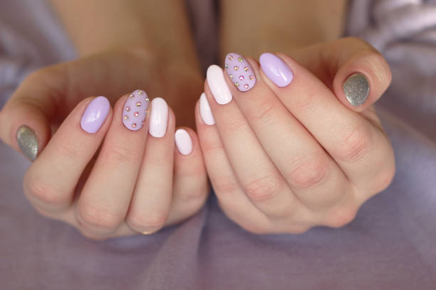 istock purple glamor manicure with crystals on a lilac background two hands 1387281906