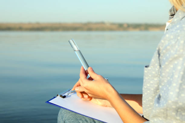 istock Scientist with clipboard and sample taken from river, closeup 1387282502