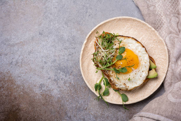 istock Sandwich with fried egg, toast, avocado, alfalfa and green pea sprouts microgreen 1387283137