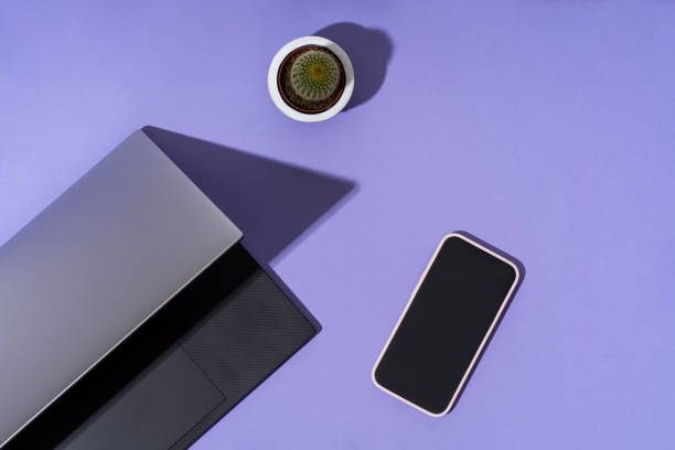 istock Laptop phone on a trendy purple background. Flat lay background. Remote work, equipment technology, computers, internet. 1387284071