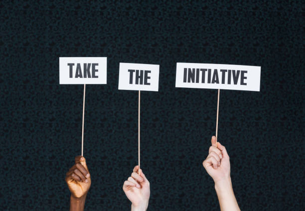 Diverse hands hold up signs saying Take The Initiative