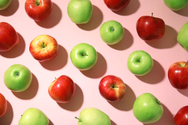 istock Many different ripe apples on pink background, flat lay 1387284702