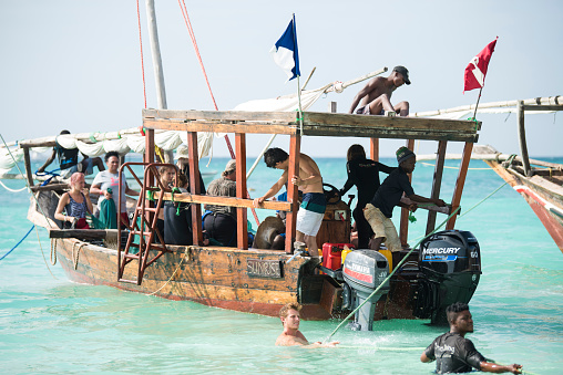 Zanzibar, Tanzania - January 02,2019: Tourists return by boat from touring the Zanzibar island to the Pongwe Bay beach.