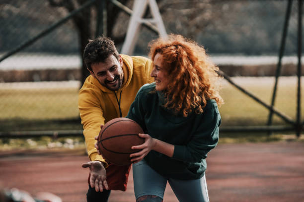 istock Two millennials playing basketball outside 1387286144