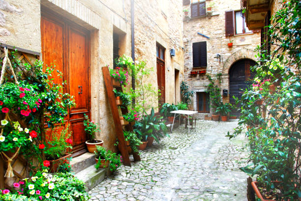 Charming floral narrow streets of typical italian villages. Spello in Umbria - famous with fllower decorated walls. Italy stock photo