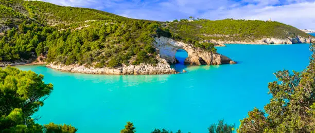 Photo of Italian holidays in Puglia - National park Gargano with beautiful turquoise sea and natural arch near Vieste town. Itay travel and nature landscape