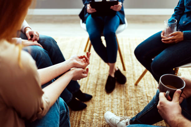 istock Mental health patient talking to the group at therapy. 1387286487