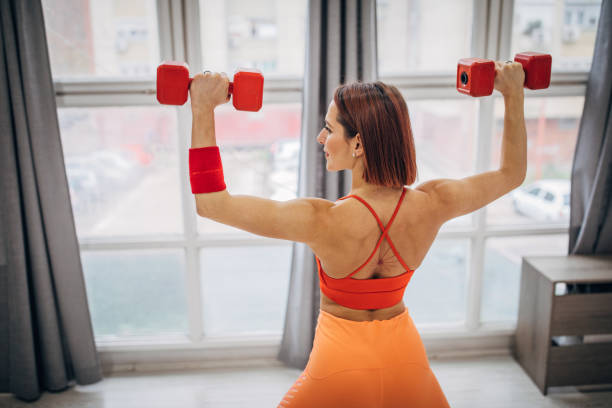 istock Woman exercising with dumbbells 1387287455