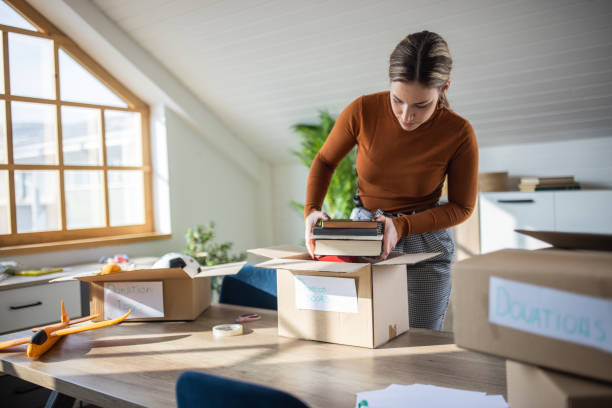 istock Volunteer packing books for donation into cardboard box 1387287503