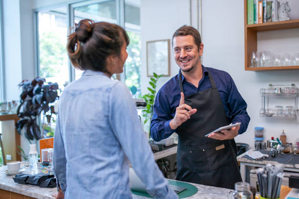 istock happy barista take order with tablet from customer. 1387287797