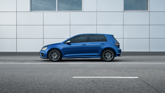 Kyiv, Ukraine - April 03 2016: blue mk7 Volkswagen Golf R in front of grey wall. Side profile view.