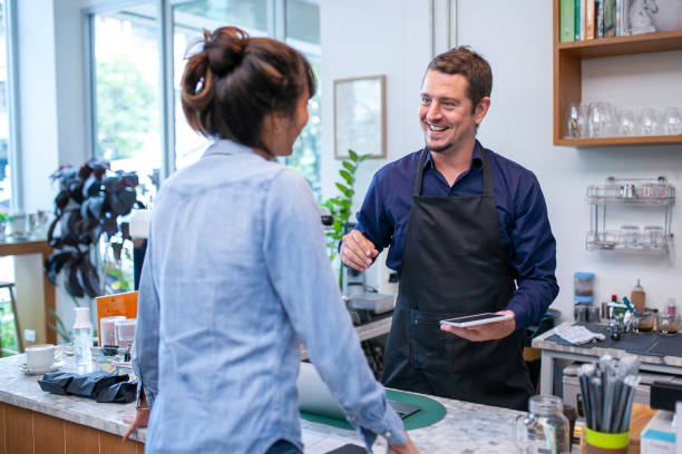 istock happy barista take order with tablet from customer. 1387288633