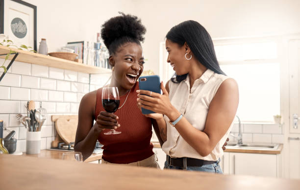 istock Shot of two young friends using a phone while spending time together at home 1387288890