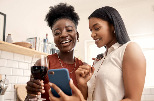 istock Shot of two young friends using a phone while spending time together at home 1387288893
