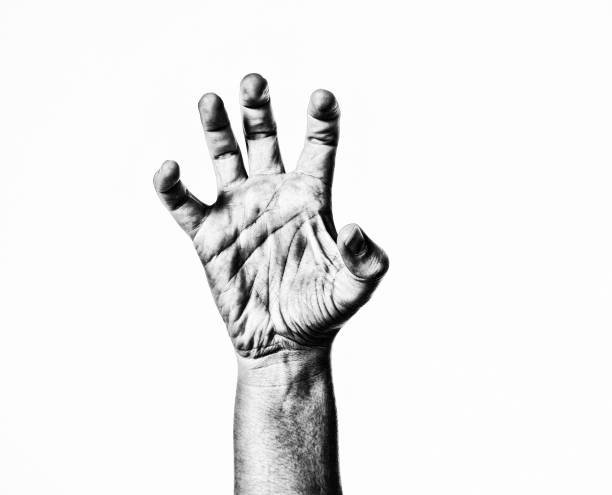 Black and white. Wrinkled left hand on a black background