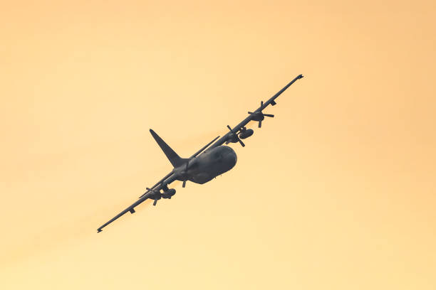 военный самолет lockheed c-130 hercules летает в воздухе во время заката - lockheed c 130 hercules military airplane military british military стоковые фото и изображения