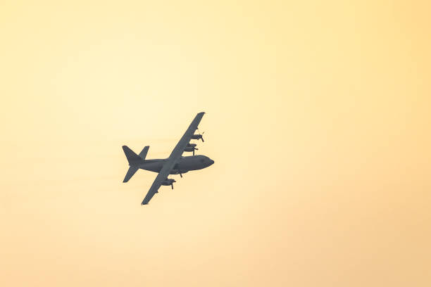 военный самолет lockheed c-130 hercules летает в воздухе во время заката - lockheed c 130 hercules military airplane military british military стоковые фото и изображения