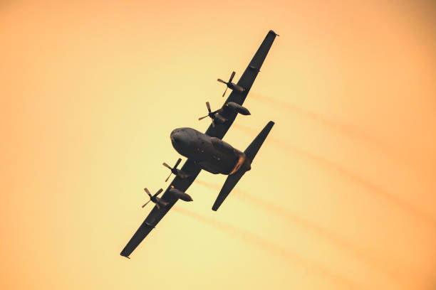 ロッキードc-130ヘラクレス軍用機は日没時に空中を飛んで - lockheed c 130 hercules military airplane military british military ストックフォトと画像