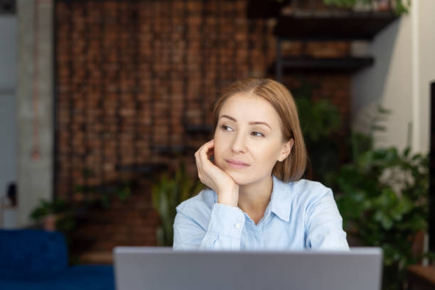 istock Pensive woman looking to side while working in home office 1387298206