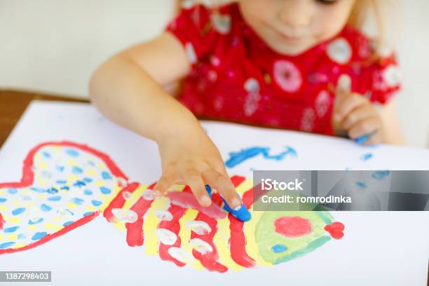 Little Creative Toddler Girl Painting With Finger Colors A Fish Active Child Having Fun With Drawing At Home In Kindergaten Or Preschool Education And Distance Learning For Kids Creaitve Activity Stock Photo - Download Image Now