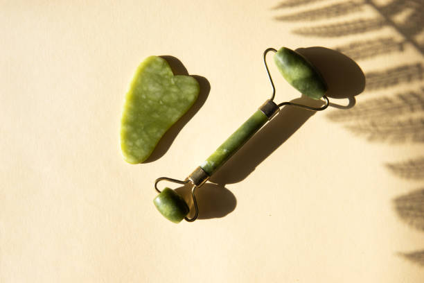 istock Jade Gua sha scraper and facial massager on beige background 1387298790