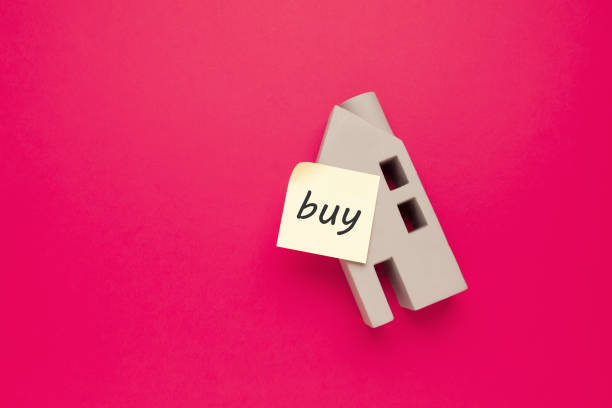 istock Buying a house, real estate miniature on a pink background, empty space for text. 1387298909