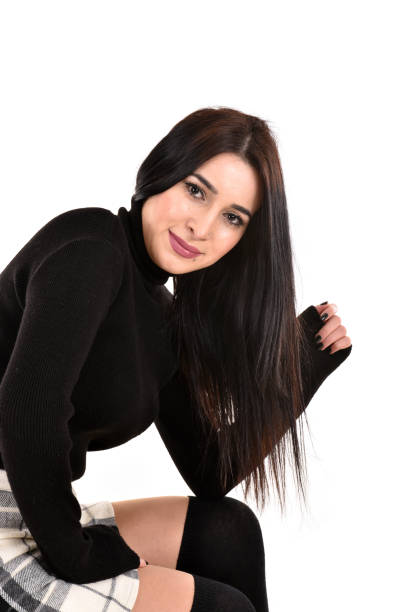 Woman looking at the dark roots if her dyed blond hair holding it back off her forehead in a close up portrait