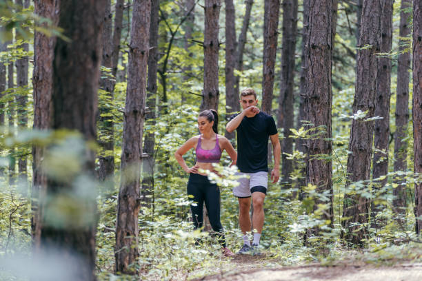 istock Fit couple taking a rest after fast running workout in the woods 1387304678