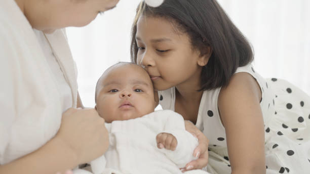 istock Mother and sister playing with baby 1387305100