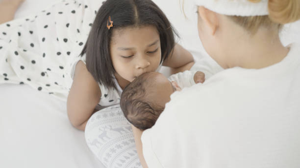 istock Mother and sister playing with baby 1387305636