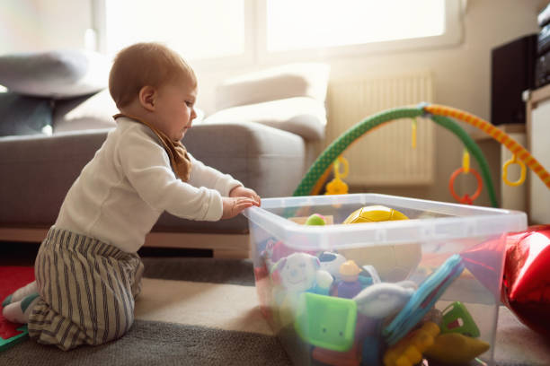 istock Curious baby boy, choosing the toy from the plastic container 1387307764