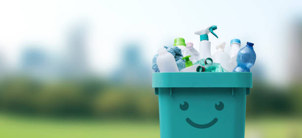 Cute smiling bin full of plastic waste stock photo