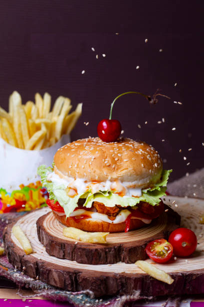 Juicy mini snack burger, hamburger or cheeseburger with one chicken patties, with sauce and french fries . Concept of American fast food. Copy space