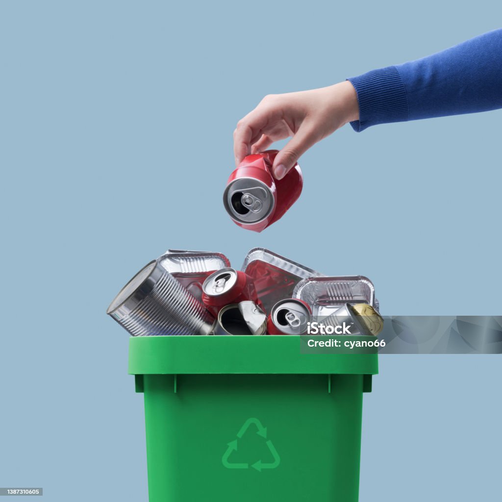 Woman throwing a can in the recycling bin Woman throwing a metal can in the recycling bin, separate waste collection concept Recycling Stock Photo
