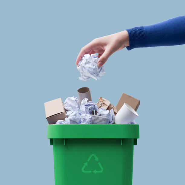 istock Woman putting paper in the waste bin 1387310631
