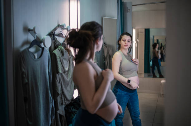 donna incinta che prova l'abbigliamento premaman. - human pregnancy clothing shopping retail foto e immagini stock