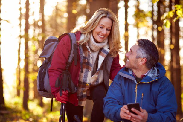 istock Mature Retired Couple Walk In Fall Or Winter Countryside Using Map Or Navigation App On Mobile Phone 1387313082