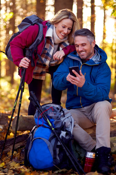 istock Mature Retired Couple Walk In Fall Or Winter Countryside Using Map Or Navigation App On Mobile Phone 1387313118