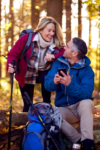 istock Mature Retired Couple Walk In Fall Or Winter Countryside Using Map Or Navigation App On Mobile Phone 1387313124