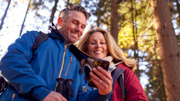 istock Mature Retired Couple Walk In Fall Or Winter Countryside Using Map Or Navigation App On Mobile Phone 1387313267