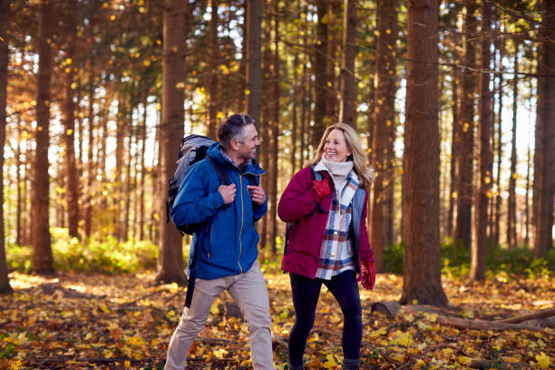 istock Mature Retired Couple With Backpacks Walking Through Fall Or Winter Countryside 1387313397