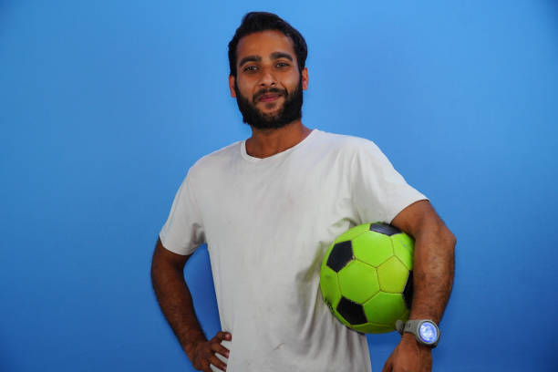 istock indian soccer player, celebrating on a blue background. 1387313813