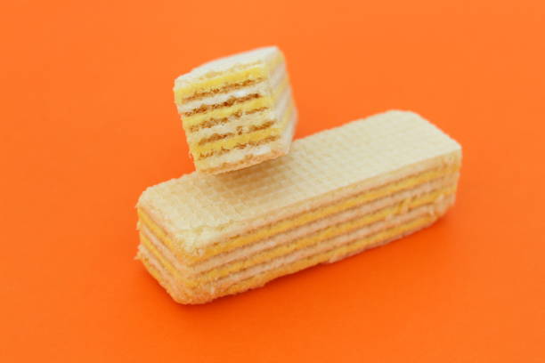 istock Two pieces of waffle lie on an orange background. 1387316438